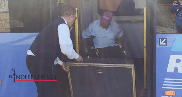 Chofer de camión ayuda a persona en silla de ruedas a subir a la unidad