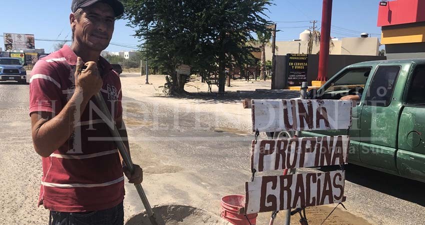 A cambio de una propina, este ciudadano tapa baches en calles de La Paz A cambio de una propina, este ciudadano tapa baches en calles de La Paz