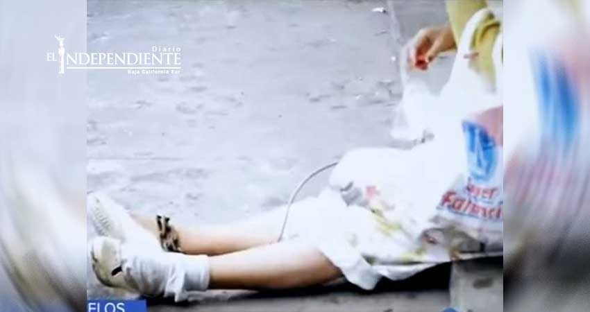 En la calle a anciana con cadenas en pies y manos