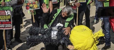 Migrantes protestan y dan nalgadas a piñata de Trump frente al muro fronterizo